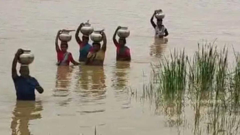 womenwadethroughfloodedrivertofetchdrinkingwaterinasifabad