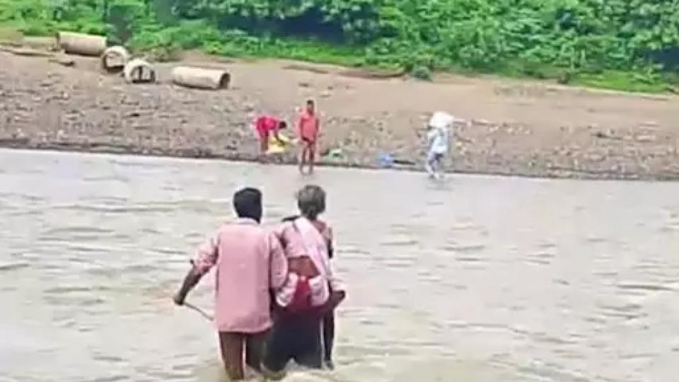 Son Carries Ailing Mother Across Flooded Stream in Asifabad dist