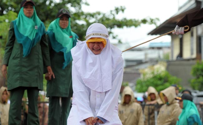 womanscreamsinpainduringcaninginindonesiaascrowdcheers