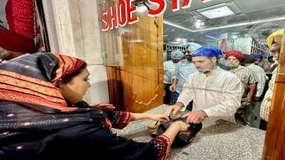 Congress leader Rahul Gandhi arranges shoes as part of his 